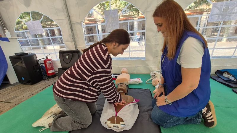 Práctica de reanimación cardiopulmonar con un maniquí en la Plaza Mayor